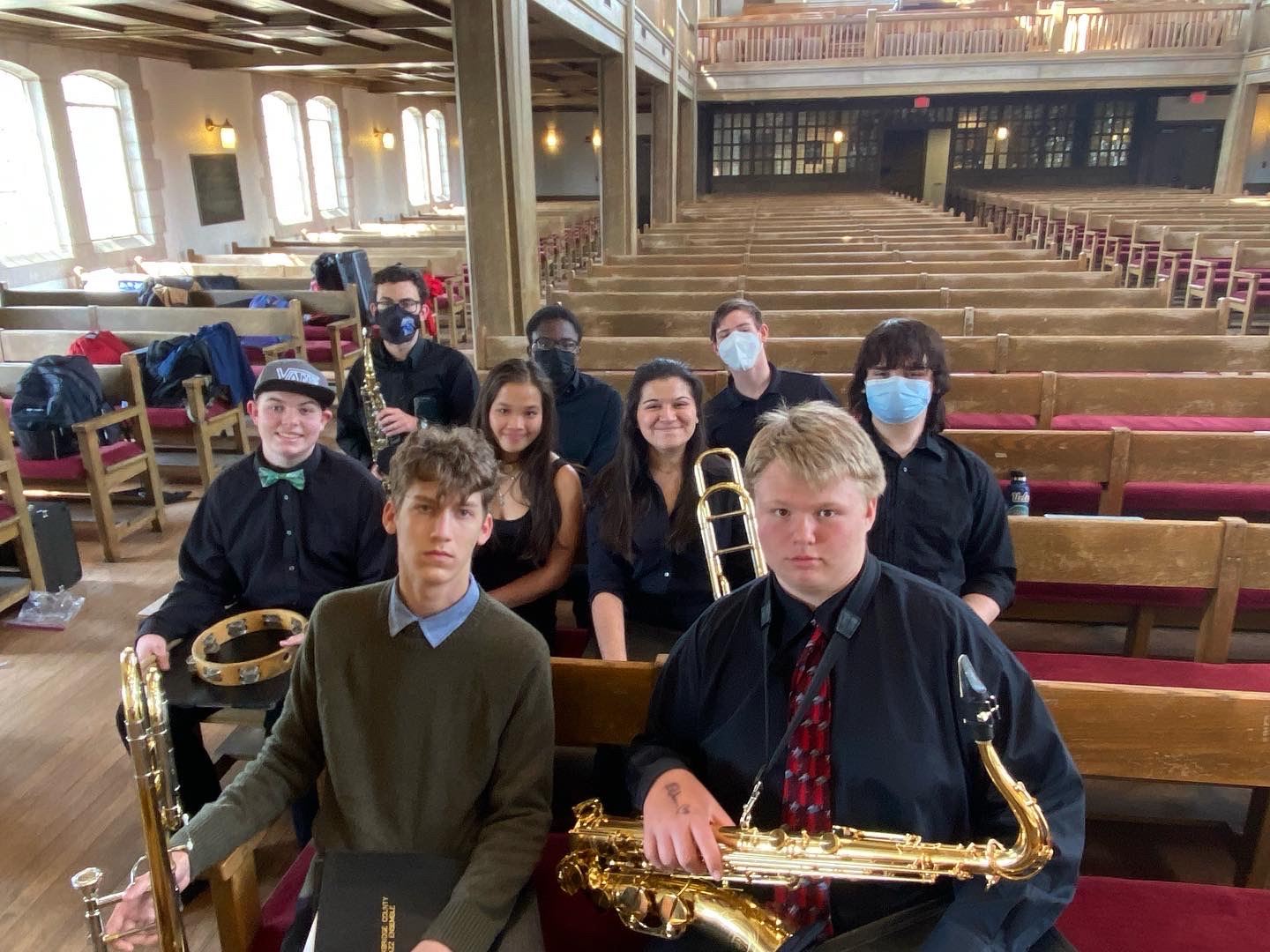 Jazz Band sitting on benches at Jazz Fest holding their instruments
